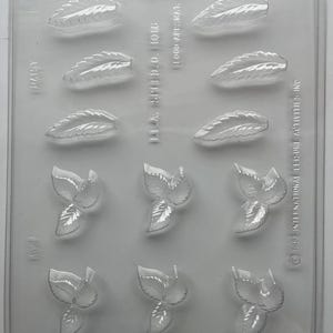 May include: Clear plastic mold with leaf and petal shapes. The mold has a rectangular shape with multiple leaf and petal impressions. The text "DAISY" and "I.L.A. SP.I.D.O. 1016" is visible on the mold.