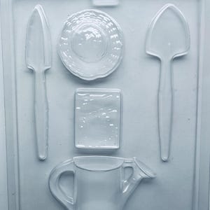 Gardening set chocolate candy mold. Set includes watering can, shovel, seed pack and hat.