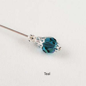 May include: Teal crystal bead with silver filigree accents on a silver pin.