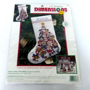 May include: A Dimensions 16-inch Santa Claws Stocking counted cross stitch kit featuring a white stocking with a group of cats dressed as Santa Claus arranged in a tree shape, topped with a star and the name Jessica embroidered at the top.