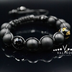 May include: Black beaded bracelet with a black onyx bead and a gold accent. The bracelet is made with black cord and has a "VALINDE HANDMADE JEWELRY" tag.