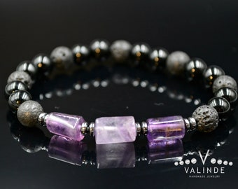 May include: A bracelet made with black lava rock, hematite, and amethyst beads. The amethyst beads are rectangular and purple.
