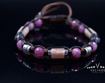 Peut inclure: Un bracelet avec des perles de pierres précieuses roses et bleues, un cordon en cuir marron et des accents métalliques argentés.