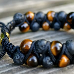 Pu&ograve; includere: Un braccialetto in cordoncino nero con perline marroni e nere. Il braccialetto ha una chiusura a nodo scorrevole.