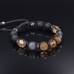 Peut inclure: Un bracelet en cordon noir avec des perles de pierres pr&eacute;cieuses brunes et grises. Le bracelet a une fermeture &agrave; n&oelig;ud coulissant.
