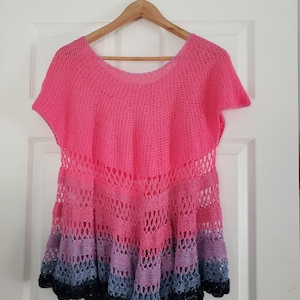 Peut inclure: Un haut en crochet rose, bleu et noir, à la coupe ample et à l'ourlet festonné.