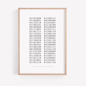 May include: A framed print with a white background and black text. The text is a series of binary code, with the phrase "Have you tried turning it off and on again?" at the bottom.