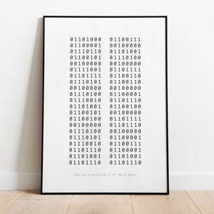 May include: A black and white framed print with a series of binary code numbers. The text below the numbers reads "Have you tried turning it off and on again?"