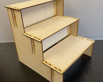May include: A three-tiered wooden display stand with a natural finish. The stand is made of plywood and has a simple, modern design.