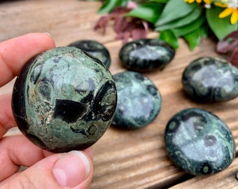 May include: A collection of six green and black polished tumbled stones. The stones have a swirling pattern of green and black.