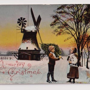 Antica cartolina di Natale del 1910: bambini al mulino a vento innevato, scena al tramonto con albero