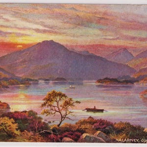 May include: Vintage postcard featuring a scenic landscape of Killarney Upper Lake. The image showcases a sunset over the lake, with mountains in the background and boats on the water. The sky is filled with vibrant colors, and the overall scene is peaceful.
