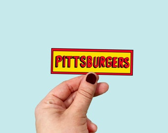 May include: A yellow and red sticker with the text "PITTSBURGERS" in red letters.