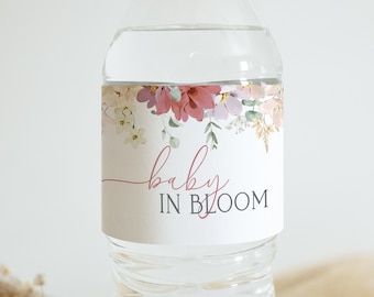 Peut inclure: Étiquette de bouteille d'eau avec un motif floral et le texte "baby in bloom" en écriture rose.