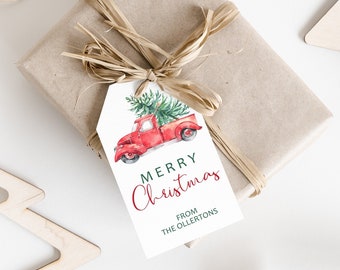 Puede incluir: Camión rojo con un árbol de Navidad en la parte superior, ilustración de acuarela en una etiqueta de regalo blanca. La etiqueta dice "Merry Christmas" en cursiva roja y "From The Ollerton's" en texto negro.