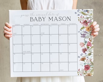 Op de afbeelding: Een witte kalender met een bloemige rand. De kalender is voor de maanden mei en juni. De tekst "guess the arrival date of BABY MASON" staat bovenaan de kalender. De uitgerekende datum is op de kalender gemarkeerd.