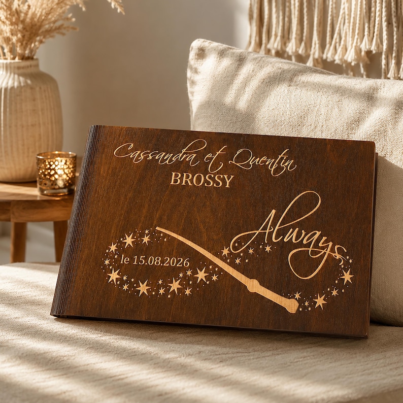 May include: A dark brown wooden book with the names "Cassandra et Quentin" and the word "Always" engraved on the cover. A wand and stars design is also engraved, along with the date "le 15.08.2026".