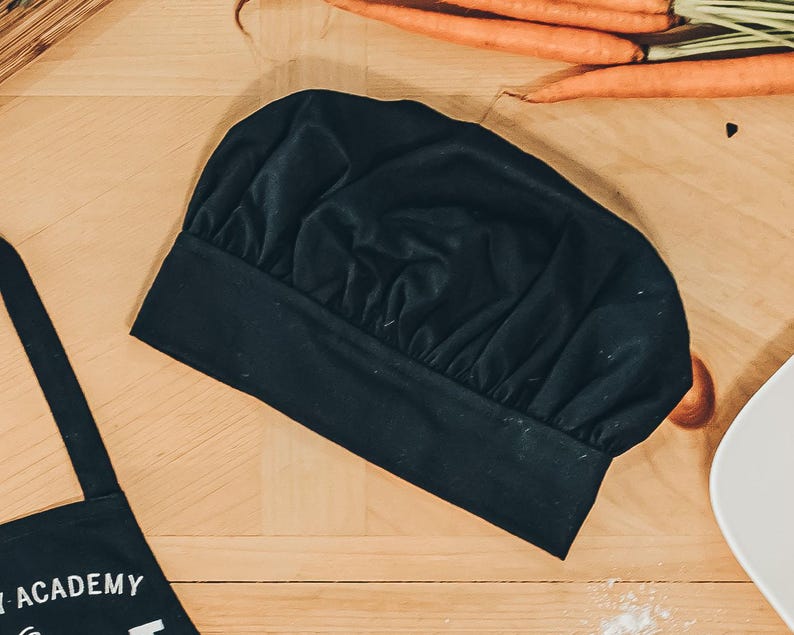 May include: A black chef's hat with a pleated design. The hat is made of a soft, fabric material.