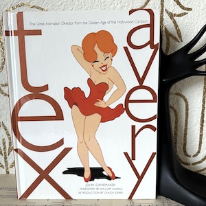 May include: A book titled "Tex Avery" featuring a cartoon illustration of a woman in a red dress. The cover has large brown letters spelling out the name. The book is about the Great Animation Director from the Golden Age of the Hollywood Cartoon.
