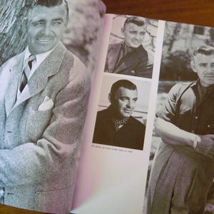 May include: Black and white photographs of Clark Gable in a book. The main image shows Gable in a patterned suit. Other images show Gable in different outfits. Text reads "All photos of Clark Gable taken in 1947."