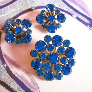 Peut inclure: Une paire de boucles d'oreilles en strass bleu. Chaque boucle d'oreille présente un groupe de strass bleus sertis dans un métal doré.