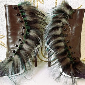 May include: A pair of brown leather high-heeled boots with a button closure and fur trim. The boots have a dark blue toe and a white sole. The fur trim is a mix of black, gray, and teal. The heels are thin and brown.
