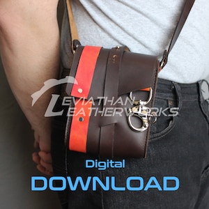 May include: A brown leather crossbody bag with an orange and black strap. The bag has a metal clasp and is worn over the shoulder of a person wearing jeans.