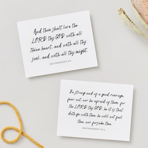 May include: Two white cards with black text on them. The top card says "And thou shalt love the LORD thy GOD with all thine heart, and with all thy soul, and with all thy might. DEUTERONOMY 6:5". The bottom card says "Be strong and of a good courage, fear not, nor be afraid of them: for The LORD thy GOD, he it is that doth go with thee: he will not fail thee, nor forsake thee. DEUTERONOMY 31:6".