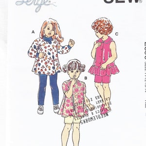May include: A vintage Kwik Sew pattern envelope, pattern number 2596, with illustrations of children's clothing designs. The designs include a tunic, dress, and shorts set. The envelope has the Kwik Sew and Serge logos.
