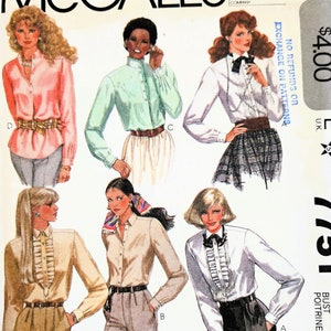 May include: A vintage McCall's sewing pattern for blouses, showcasing several designs with diverse collar and cuff styles. The pattern, marked as "7751", includes the text "Liz Claiborne". The price tag shows £4.00.