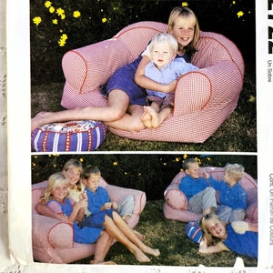 May include: A sewing pattern for a red and white gingham fabric armchair with a red piping trim. The pattern is from McCall's Home Decorating and is for a child-sized armchair. The pattern number is 2722.