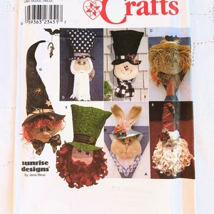 May include: A Simplicity Crafts pattern for making six different door hangers. The pattern includes a witch, a snowman, a scarecrow, a leprechaun, a bunny, and a Santa Claus. The pattern is called "Sunrise Designs" by Jana Beus.