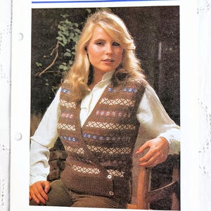 May include: A vintage magazine page with the title "Fair Isle vest" and a woman wearing a brown and blue patterned vest over a white shirt. The vest has a button closure and a geometric design.
