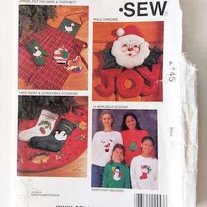 May include: A Kwik Sew pattern packet showcasing Christmas sewing projects. The cover shows an apron, pot holders, oven mitt, wall hanging, tree skirt, Christmas stocking, and appliqued designs. The pattern number is 2445.
