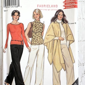 May include: A sewing pattern for three different outfits. The first outfit is a red long-sleeved shirt with black pants. The second outfit is a leopard print sleeveless top with white pants. The third outfit is a beige cape with a white turtleneck and beige pants. The pattern is for sizes 10-22.