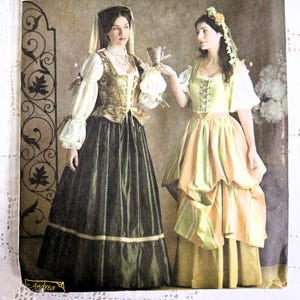 May include: Simplicity Renaissance Costume Collection pattern featuring two women in period dresses. The pattern includes sizes 4, 6, and 8. The cover displays a woman in a dark green dress and another in a yellow and green dress.