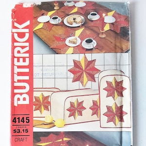May include: A vintage craft pattern for making star-shaped placemats and table runners. The pattern is from Butterick and is number 4145. The pattern shows a table setting with red and yellow placemats and runners.
