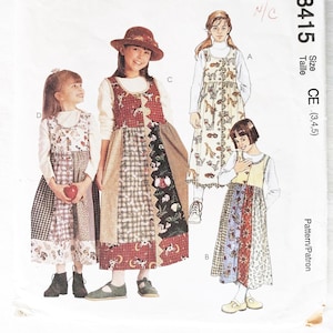 May include: A vintage McCall's sewing pattern featuring illustrations of children's dresses. The pattern includes multiple dress designs with patchwork and patterned fabric details. The pattern number is 8415, with size options.