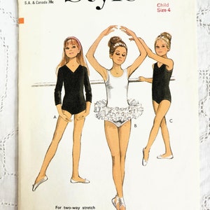 May include: A vintage sewing pattern for a child's leotard and tutu. The pattern is for size 4 and includes instructions for making a black leotard, a white leotard with a ruffled tutu, and a black tank leotard. The pattern is from Style magazine and is number 2864.