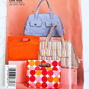 May include: Simplicity sewing pattern with multiple bag designs. The pattern shows a light blue tote bag, an orange clutch, a striped tote, and a polka dot bag. The text "IT'S SO easy" and "Simplicity" are visible on the pattern.