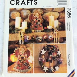 May include: McCall's Crafts pattern featuring angel and wreath designs. The cover displays a plaid angel figurine, a wreath with star accents, and a garland with angel ornaments. The pattern includes instructions for creating fabric crafts.