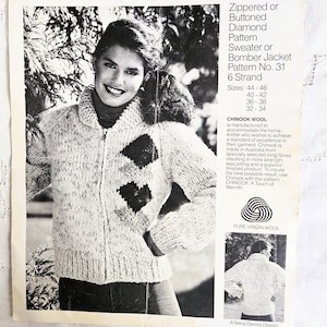 Puede incluir: Imagen en blanco y negro de un patrón de tejido vintage para un suéter o chaqueta bomber con cremallera o botones y estampado de diamantes. El patrón está etiquetado como "Chinook" e incluye tallas e información sobre el hilo. La imagen muestra a una mujer que lleva el suéter.