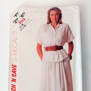 May include: A white sewing pattern featuring a woman wearing a white button-down shirt with a brown belt and a white and brown striped skirt. The pattern is for McCall's 3113 Stitch 'n Save.
