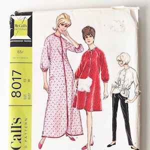 May include: A vintage sewing pattern for a robe or jacket and pants. The pattern is for misses' sizes 10-31 and includes three different styles. The pattern is printed on yellow paper with a red and white floral design.