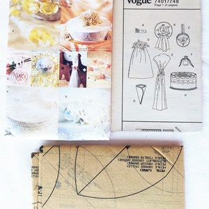 Puede incluir: Un patr&oacute;n de costura vintage de Vogue Accessories para hacer accesorios de boda. El patr&oacute;n incluye instrucciones para hacer un adorno para pastel, un ramo, una cesta para la ni&ntilde;a de las flores, un coj&iacute;n para anillos y una bolsa de regalo. El patr&oacute;n es para la talla uno y est&aacute; en ingl&eacute;s. El patr&oacute;n est&aacute; sobre un fondo blanco con texto negro e ilustraciones.