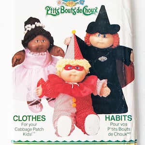 May include: A vintage sewing pattern for Cabbage Patch Kids clothing. The pattern includes three outfits: a pink ballerina dress, a red and white clown costume, and a black witch costume. The pattern is titled "Cabbage Patch Kids" and "P'tits Bouts de Choux" and is from Butterick.