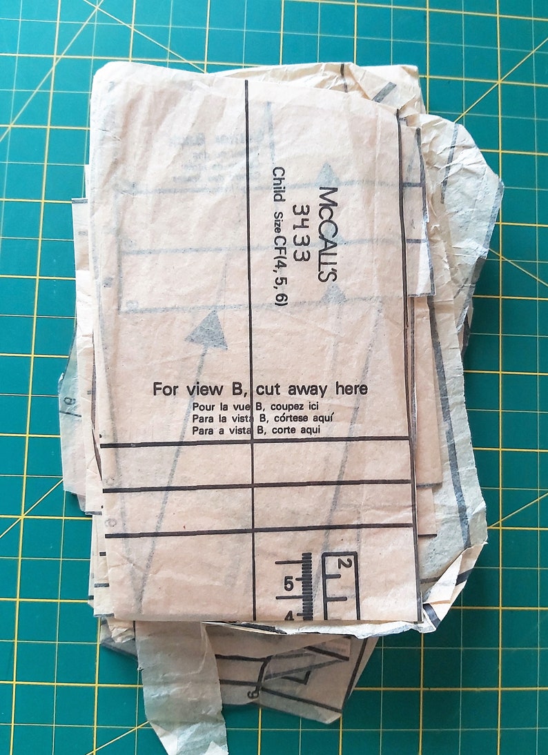 May include: A close-up of a McCall's sewing pattern for children's clothing. The pattern is for sizes 4, 5, and 6. The pattern is for view B and includes instructions to cut away a portion of the fabric. The pattern is labeled "3433".