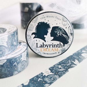 Pode incluir: Rolos de fita washi decorativa com um design azul escuro e branco. A fita apresenta silhuetas de duas pessoas e as palavras "Labyrinth Dream". A fita tem 10 m de comprimento e apresenta um padrão repetitivo de estrelas e outras imagens.