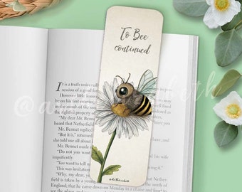 May include: A bookmark featuring a bee on a daisy with the text "To Bee Continued".