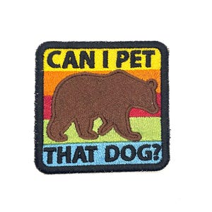 May include: Embroidered patch with a brown bear silhouette and the text "CAN I PET THAT DOG?" in yellow and blue. The patch has a square shape with a black border and a colorful striped background.